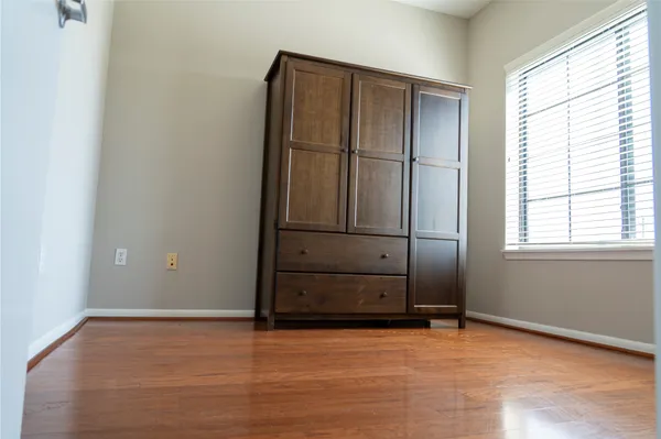 a view of a room with wooden floor and a window
