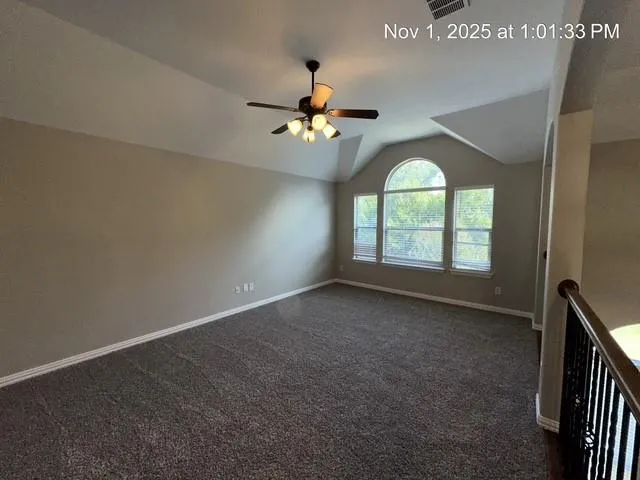 en empty room with windows and ceiling fan