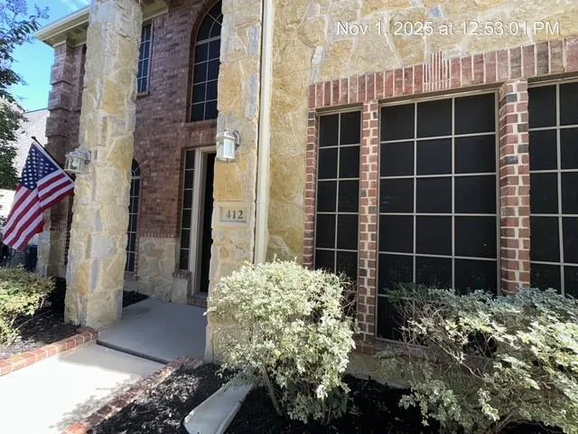 a view of a house with a potted plant and a building in the background