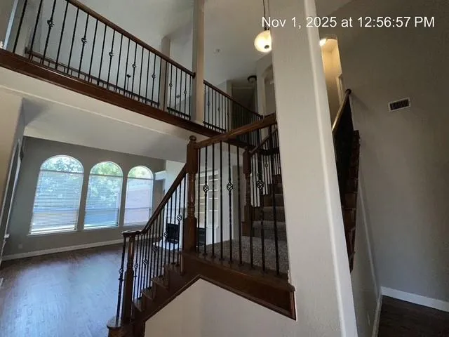 a view of staircase with railing and a chandelier