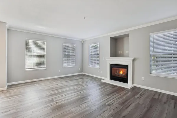an empty room with windows and fireplace