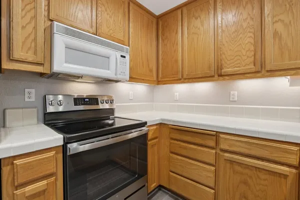 a kitchen with stainless steel appliances a refrigerator sink and white cabinets