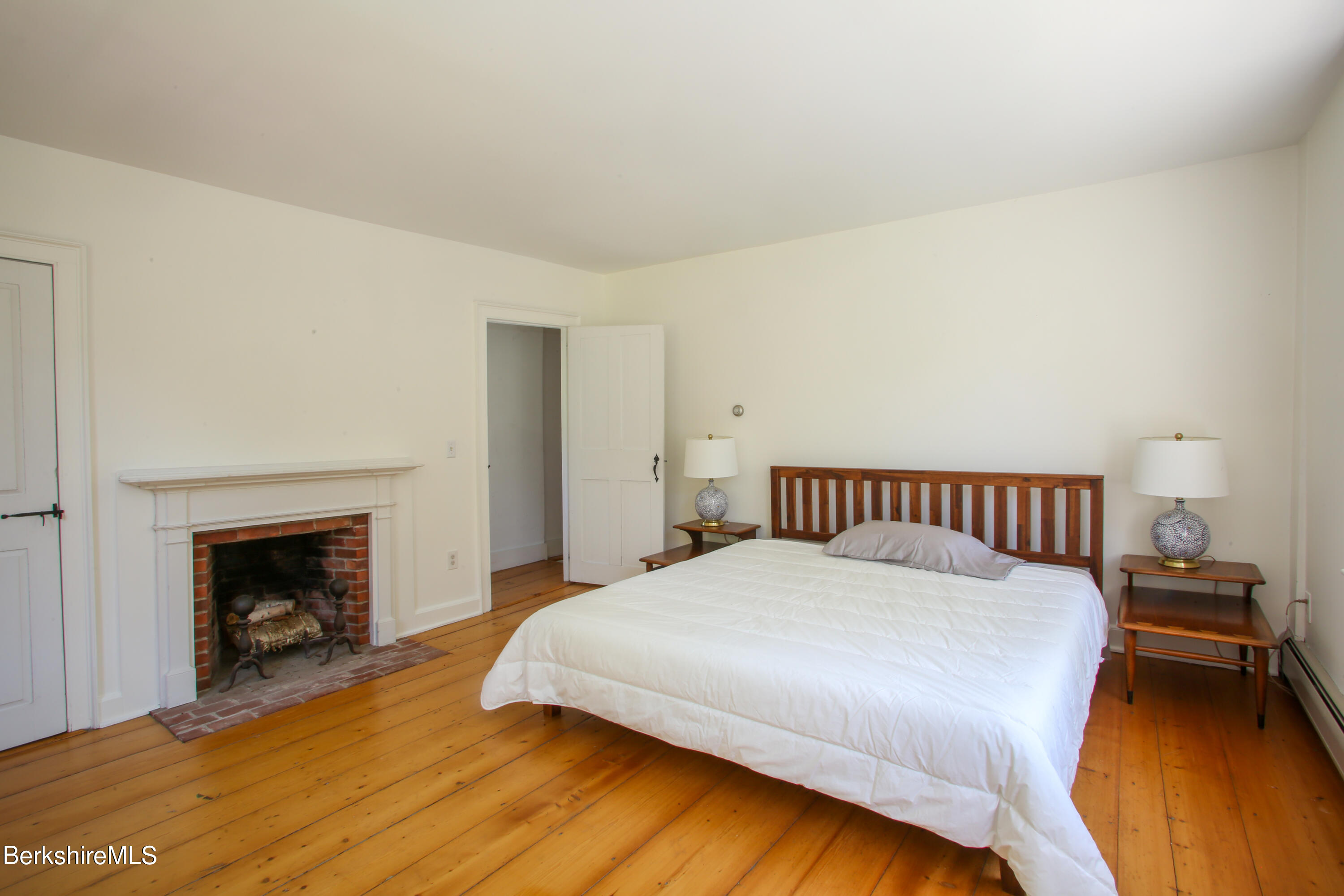 228 Zoar Road Rowe, MA 01367 - Photo 32 of 50 a bedroom with a bed and a fireplace