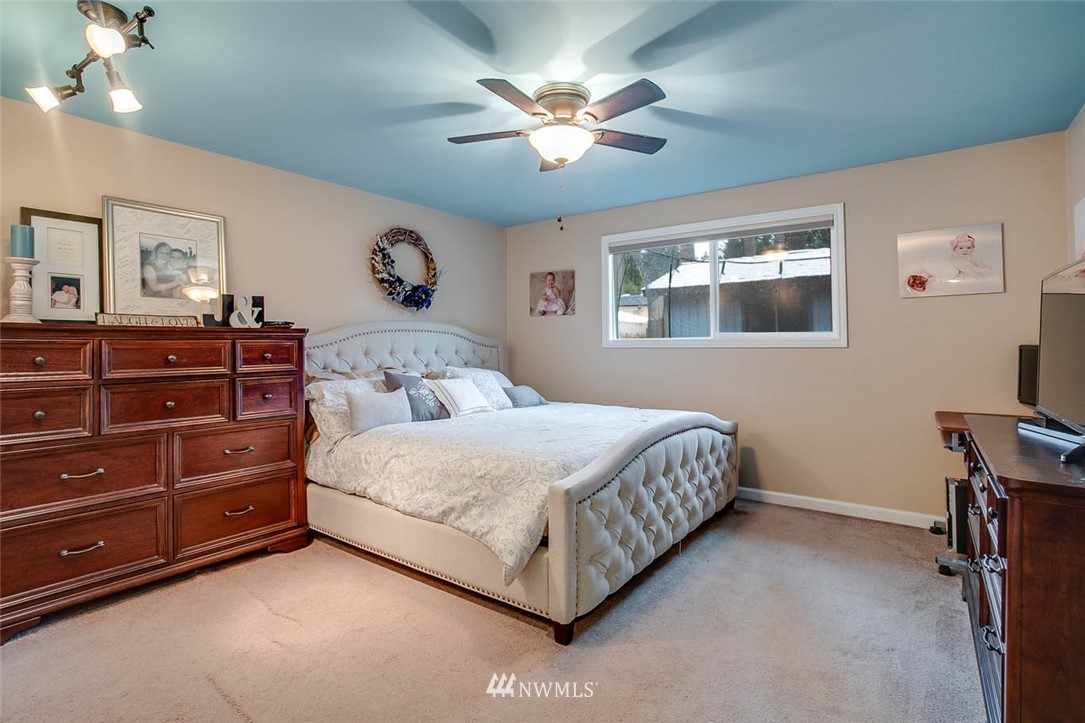 16120 Southeast 145th Place Renton, WA 98059 - Photo 15 of 22 a bedroom with a bed chandelier painting on the wall and a window