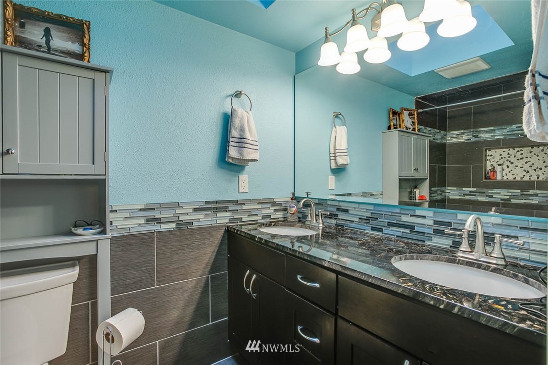 16120 Southeast 145th Place Renton, WA 98059 - Photo 16 of 22 a bathroom with a granite countertop sink a large mirror and a toilet