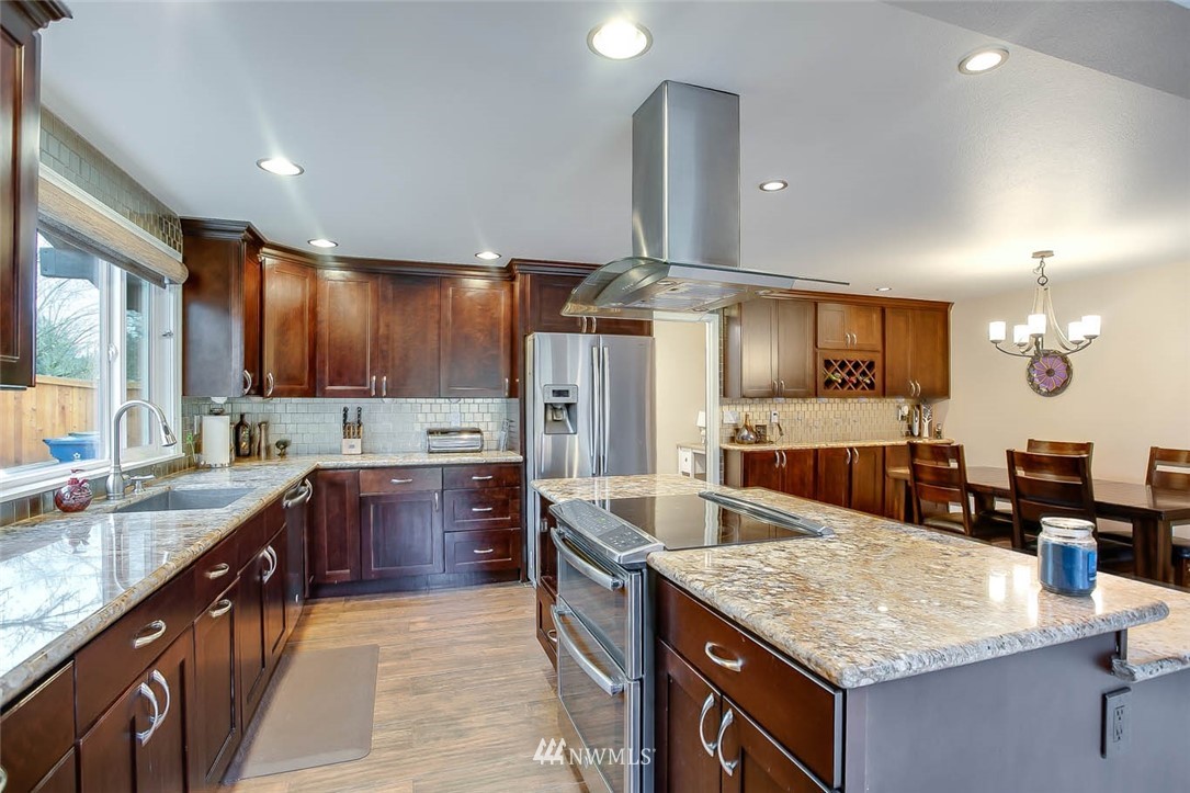 16120 Southeast 145th Place Renton, WA 98059 - Photo 4 of 22 a kitchen with granite countertop counter space a sink stainless steel appliances and cabinets