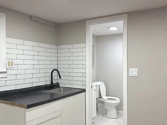 a bathroom with a toilet sink and mirror