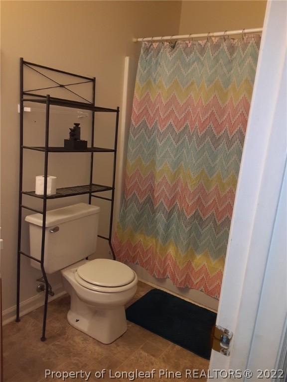 76 Woodbridge Drive Spring Lake, NC 28390 - Photo 6 of 13 a bathroom with a toilet and a shower curtain