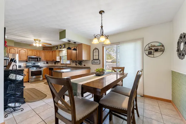 a view of a dining room and livingroom with furniture wooden floor a chandelier