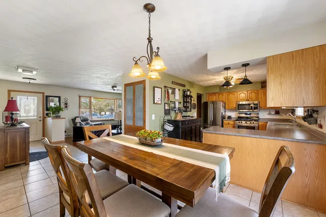 a view of a dining room and livingroom with furniture wooden floor a chandelier