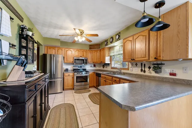 a kitchen with stainless steel appliances granite countertop a sink a stove and a refrigerator