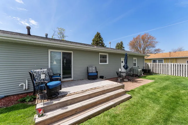 a view of a patio with table and chairs with wooden fence