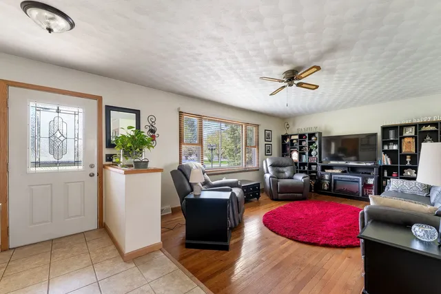 a living room with furniture a flat screen tv and a window