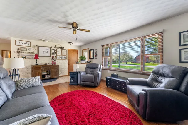 a living room with furniture fireplace and a large window