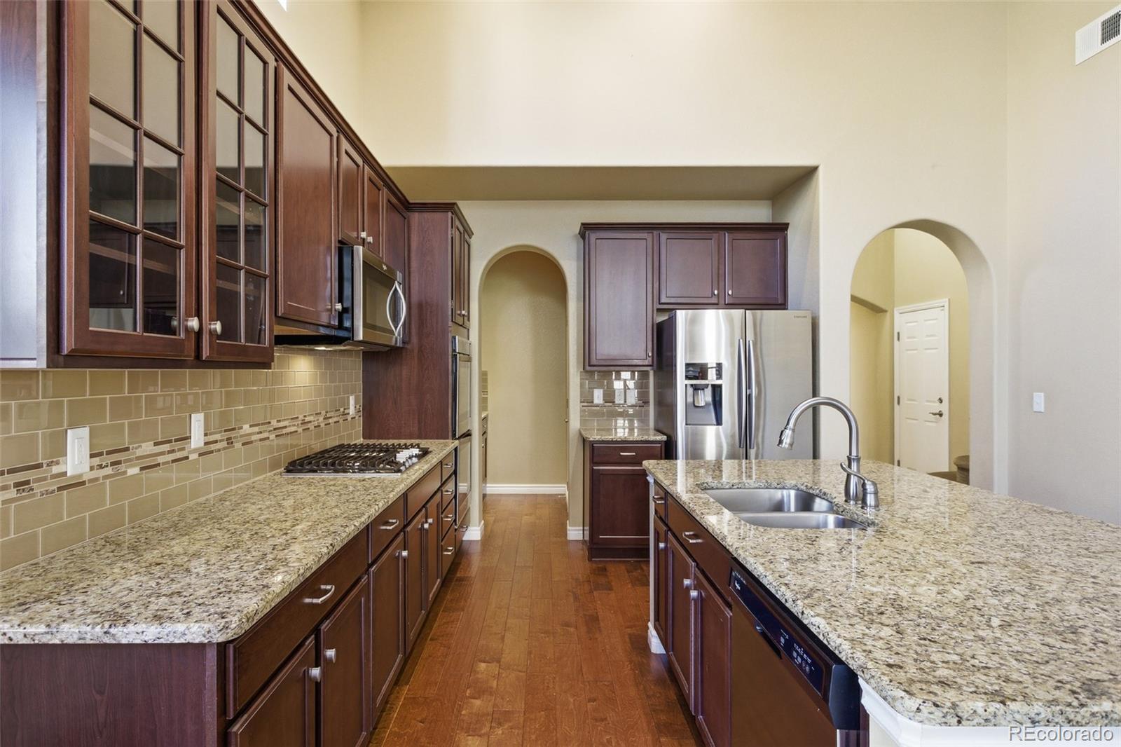 9470 Sori Lane Highlands Ranch, CO 80126 - Photo 11 of 32 a kitchen with granite countertop kitchen island a sink stainless steel appliances and cabinets