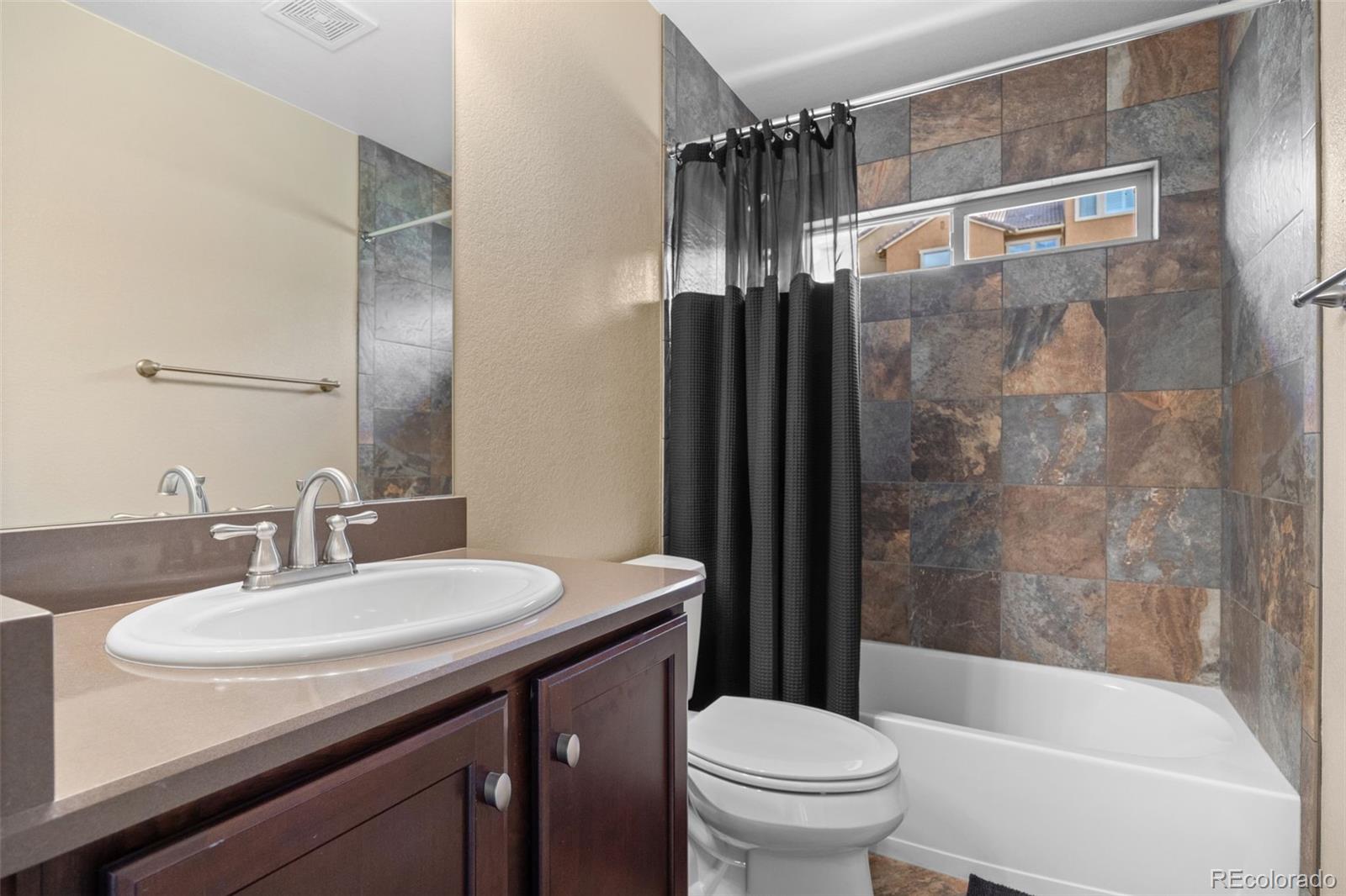 9470 Sori Lane Highlands Ranch, CO 80126 - Photo 27 of 32 a bathroom with a sink a toilet and a mirror