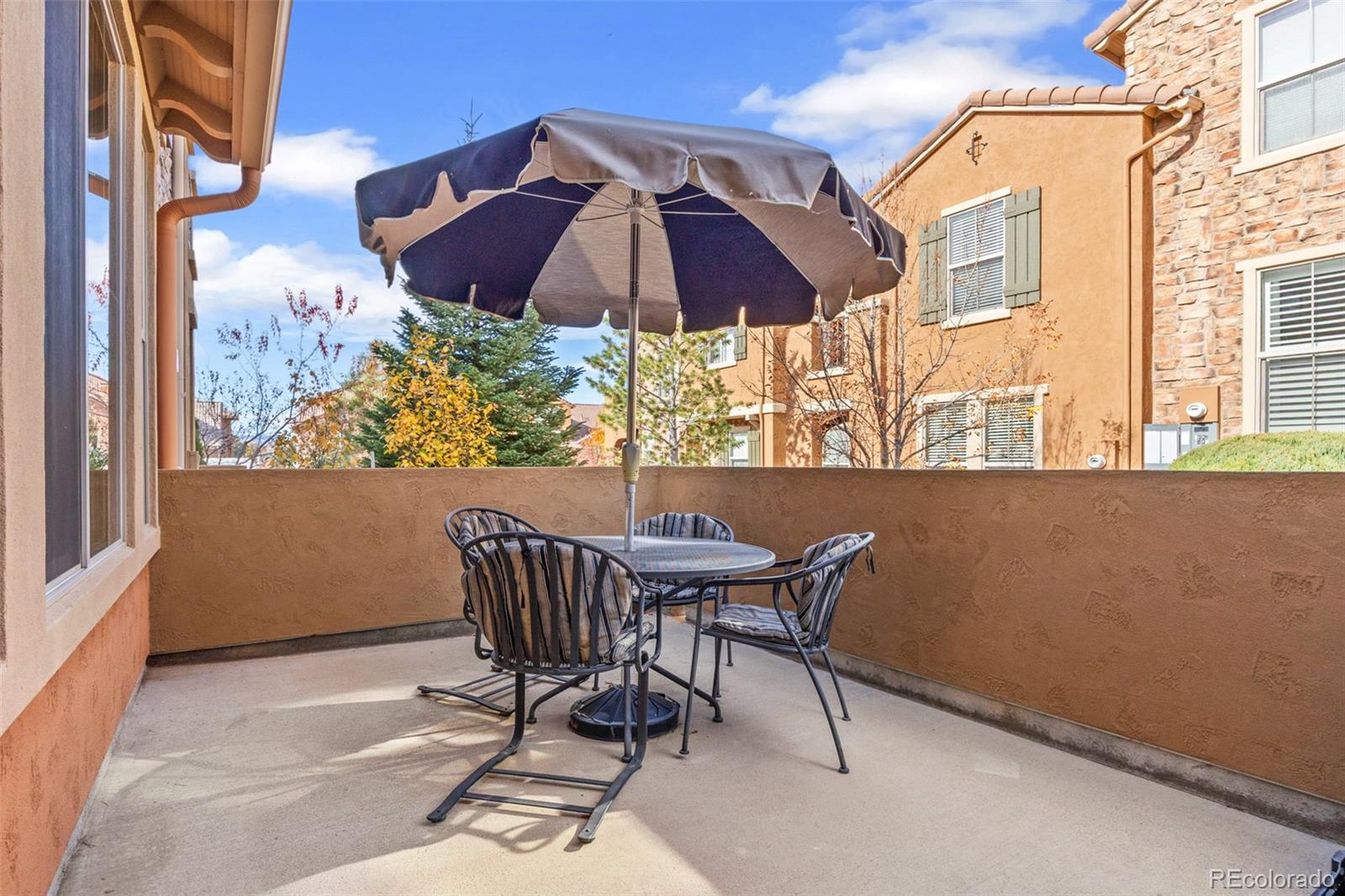 9470 Sori Lane Highlands Ranch, CO 80126 - Photo 28 of 32 a view of balcony with furniture and umbrella