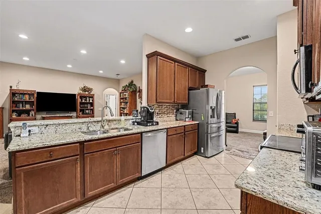 a kitchen with stainless steel appliances granite countertop a sink stove and refrigerator
