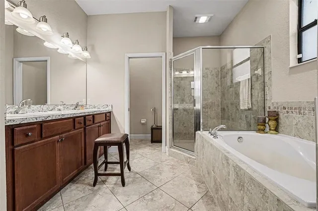 a spacious bathroom with a bathtub shower sink and mirror