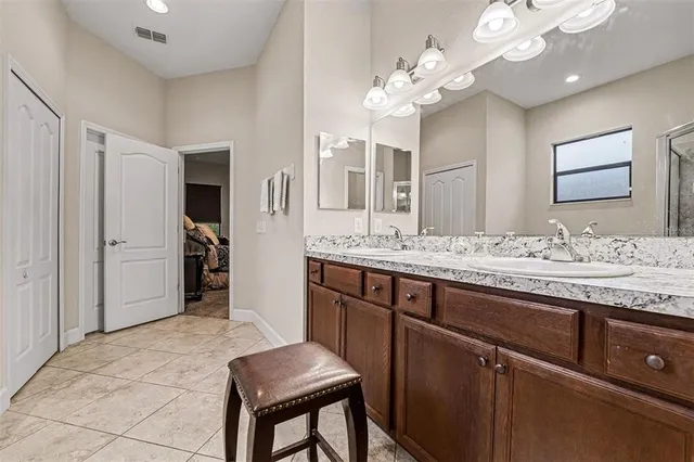 a spacious bathroom with a granite countertop sink a mirror and a shower
