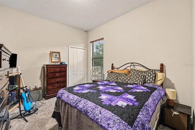 a bedroom with a bed a dresser and a flat screen tv