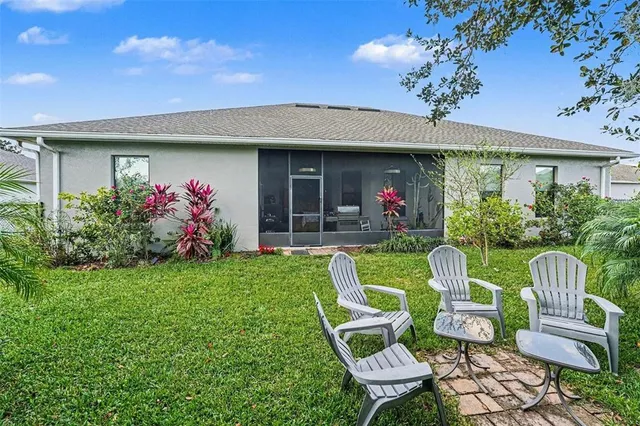 a view of a chair and table in the back yard of the house