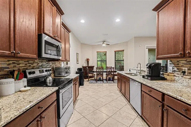 a kitchen with stainless steel appliances granite countertop sink stove top oven and cabinets