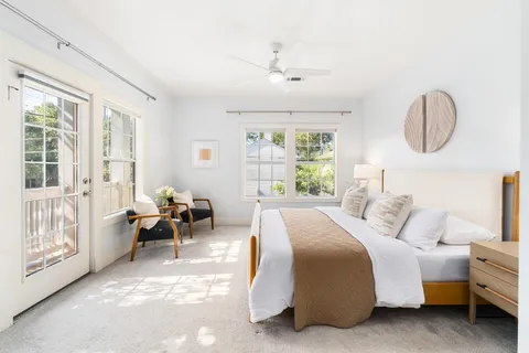 a bedroom with bed and a large window