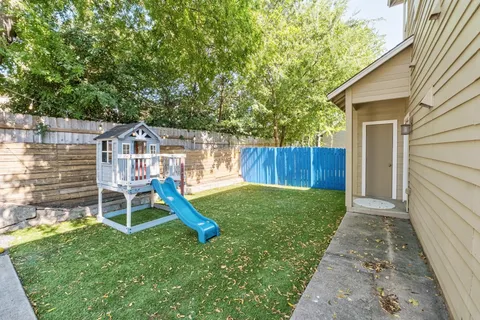 a view of a chair and table in backyard of the house