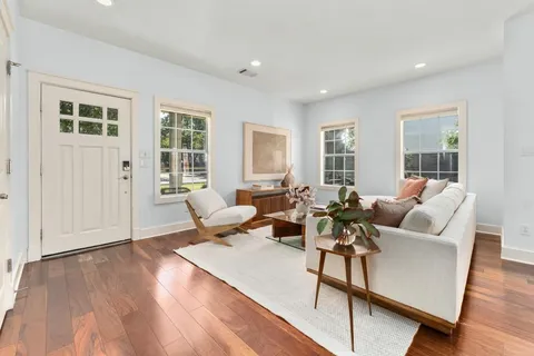 a living room with furniture and wooden floor