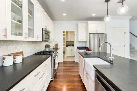 a kitchen with kitchen island granite countertop a sink stainless steel appliances and cabinets