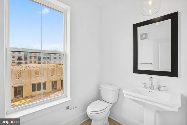 a bathroom with a toilet a sink and a mirror