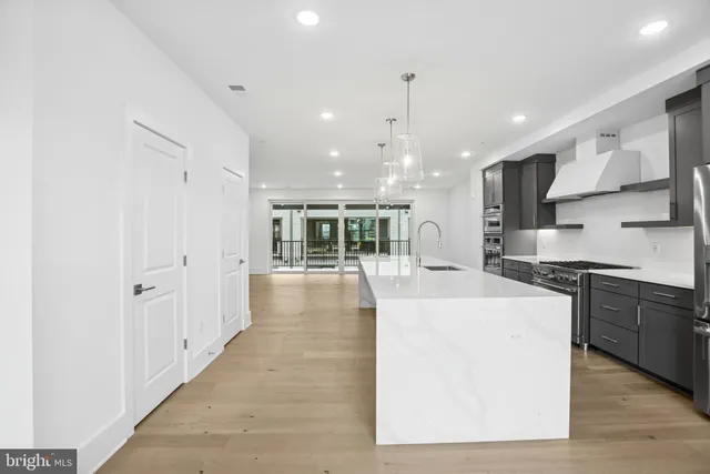 a large white kitchen with stainless steel appliances