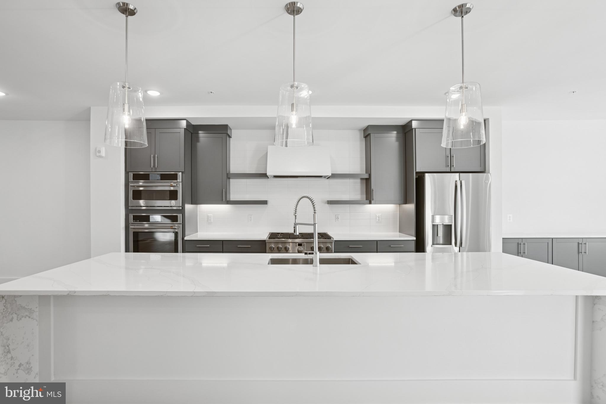 120 B Locke Street, Unit 2025 Baltimore, MD 21230 - Photo 20 of 31 a view of a kitchen with center island and stainless steel appliances