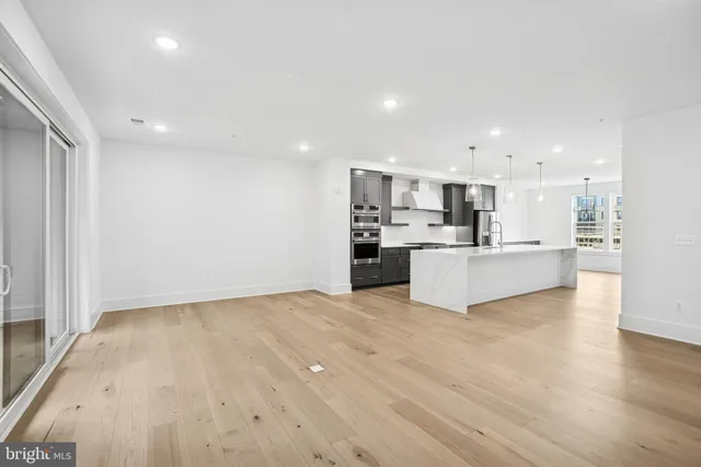 a view of kitchen with kitchen island a sink wooden floor and white stainless steel appliances
