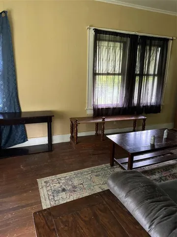 a living room with furniture window and wooden floor