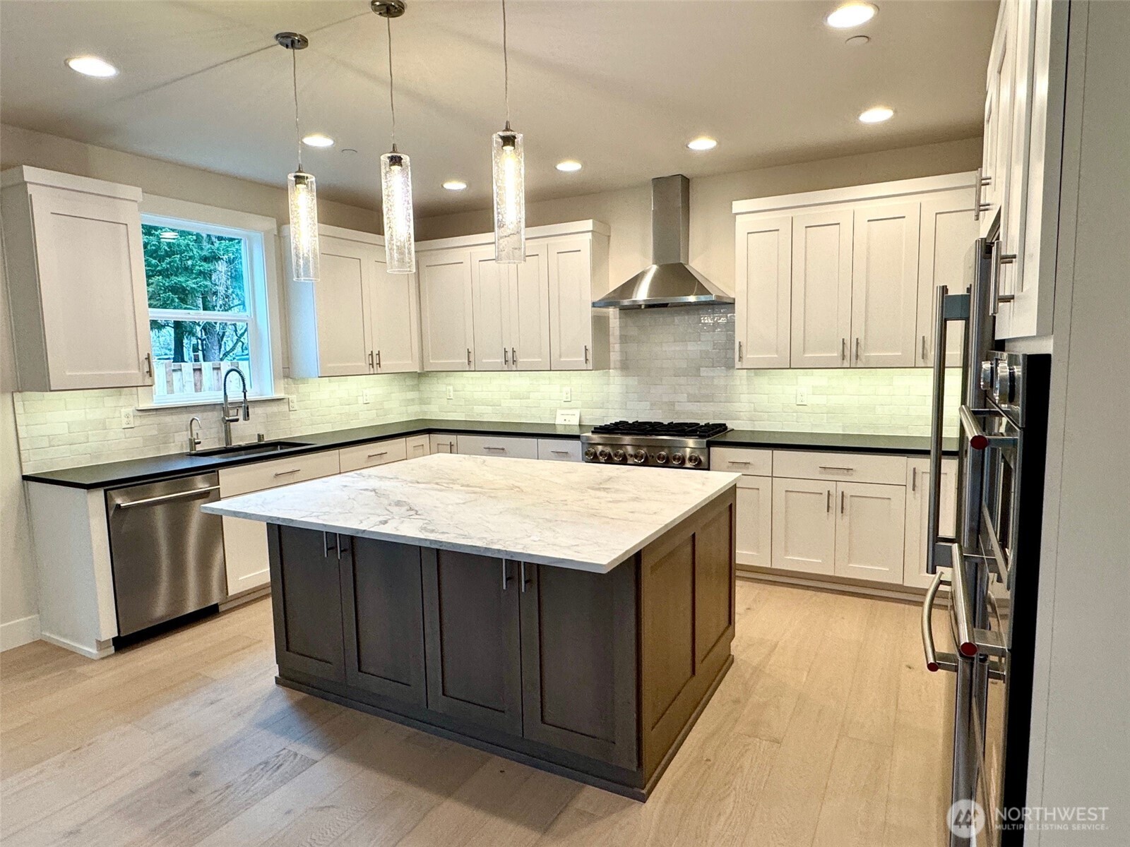 9207 Northeast 175th Street, Unit B Bothell, WA 98011 - Photo 9 of 33 a kitchen with granite countertop kitchen island stainless steel appliances a sink stove and refrigerator