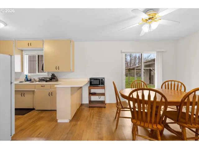 a kitchen with stainless steel appliances a dining table chairs and granite counter tops