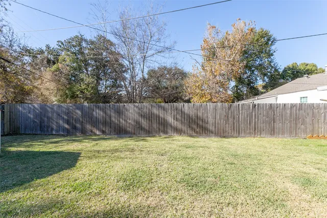 a view of a backyard with wooden fence