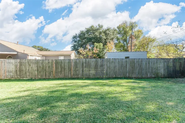 a view of a yard with wooden fence
