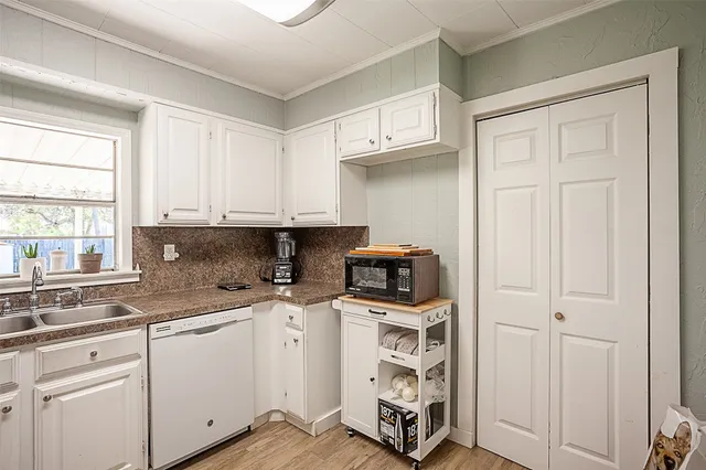 a kitchen with stainless steel appliances white cabinets and a sink