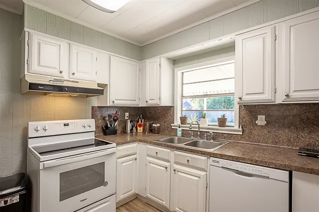 a kitchen with granite countertop white cabinets and white appliances