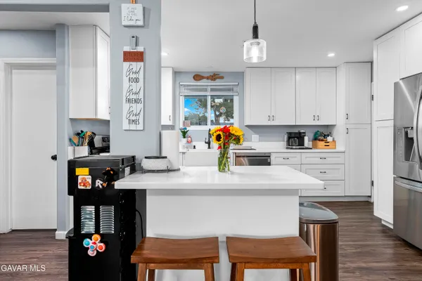 a kitchen with stainless steel appliances a sink a stove a refrigerator and cabinets