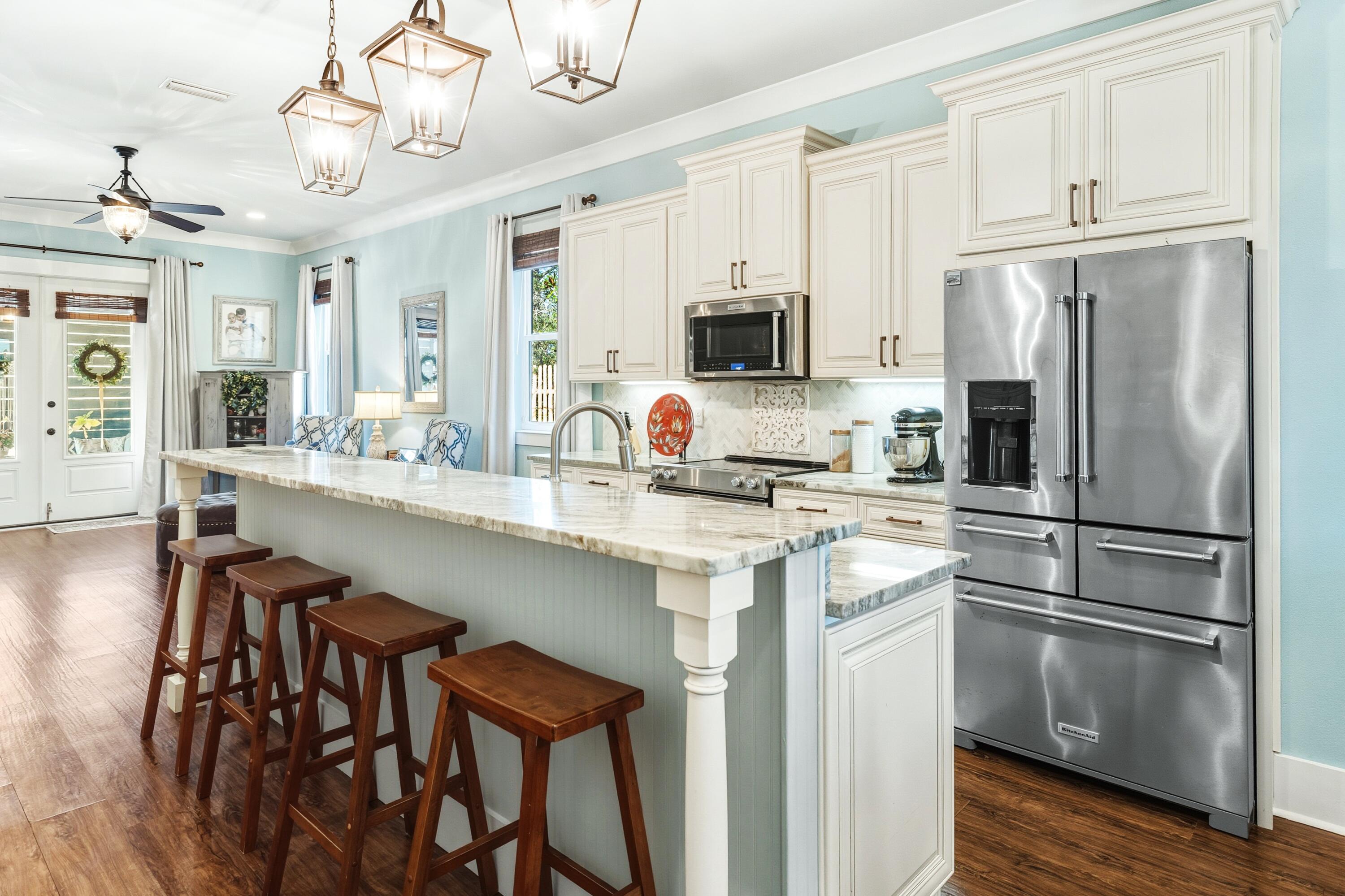 101 Botany Boulevard Santa Rosa Beach, FL 32459 - Photo 18 of 53 a kitchen with stainless steel appliances granite countertop a refrigerator a stove a sink dishwasher a dining table and chairs with wooden floor