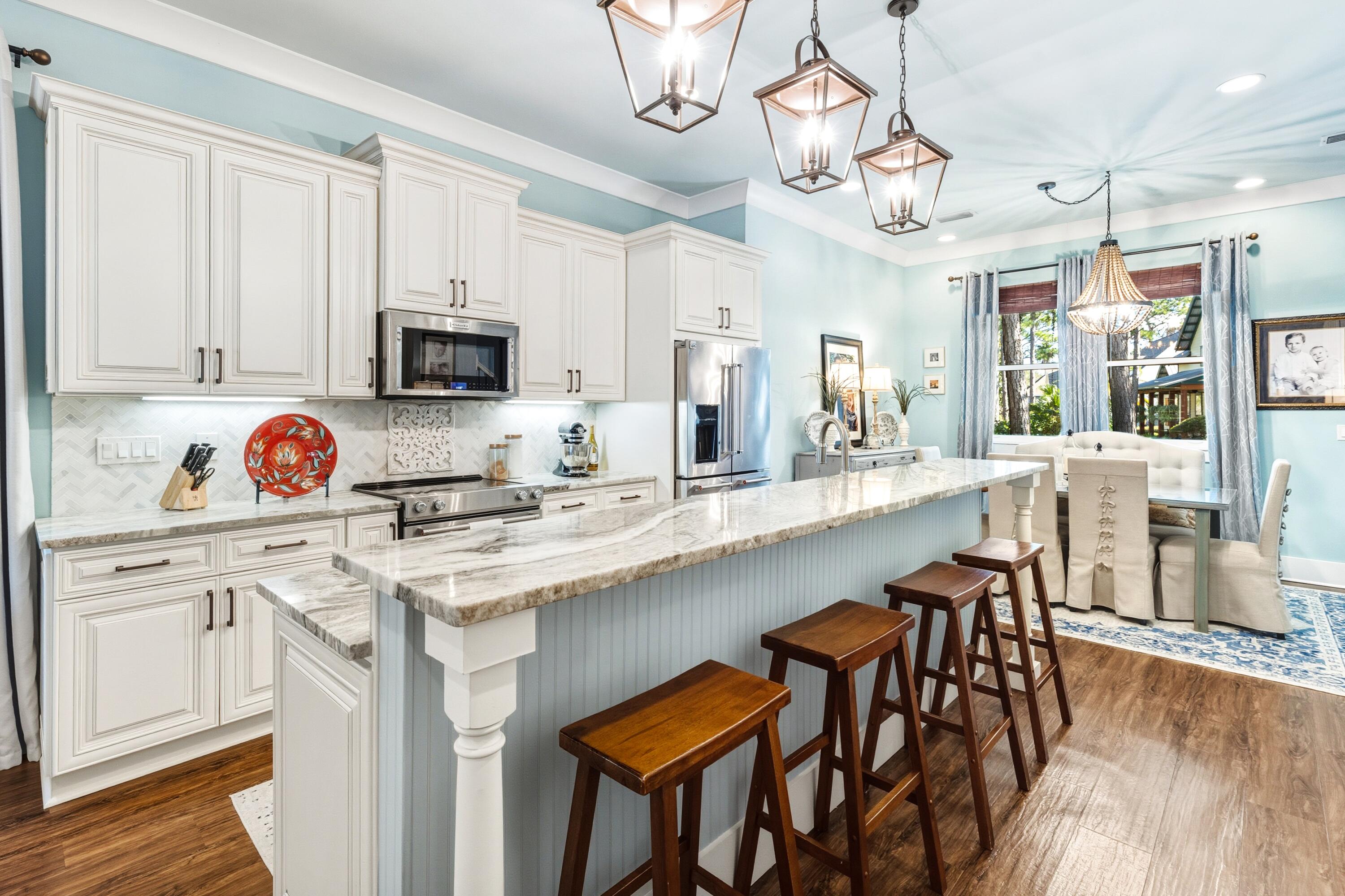 101 Botany Boulevard Santa Rosa Beach, FL 32459 - Photo 19 of 53 a kitchen with stainless steel appliances granite countertop a stove a sink dishwasher a dining table and chairs with wooden floor