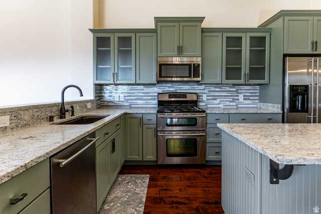 5326 North Oldgate Road Heber City, UT 84032 - Photo 8 of 32 Kitchen featuring green cabinetry, light-toned countertops, a mosaic tile backsplash, stainless steel appliances, and wood-finish flooring