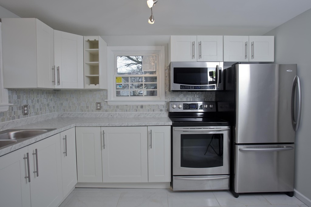 93 Haskin Street Springfield, MA 01109 - Photo 3 of 27 a kitchen with white cabinets and stainless steel appliances