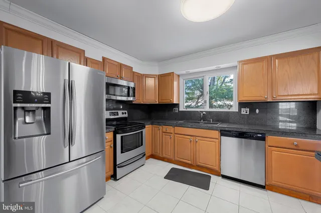 a kitchen with stainless steel appliances granite countertop a refrigerator and a stove top oven