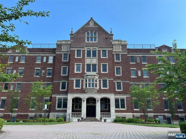 a front view of a residential apartment building with a yard
