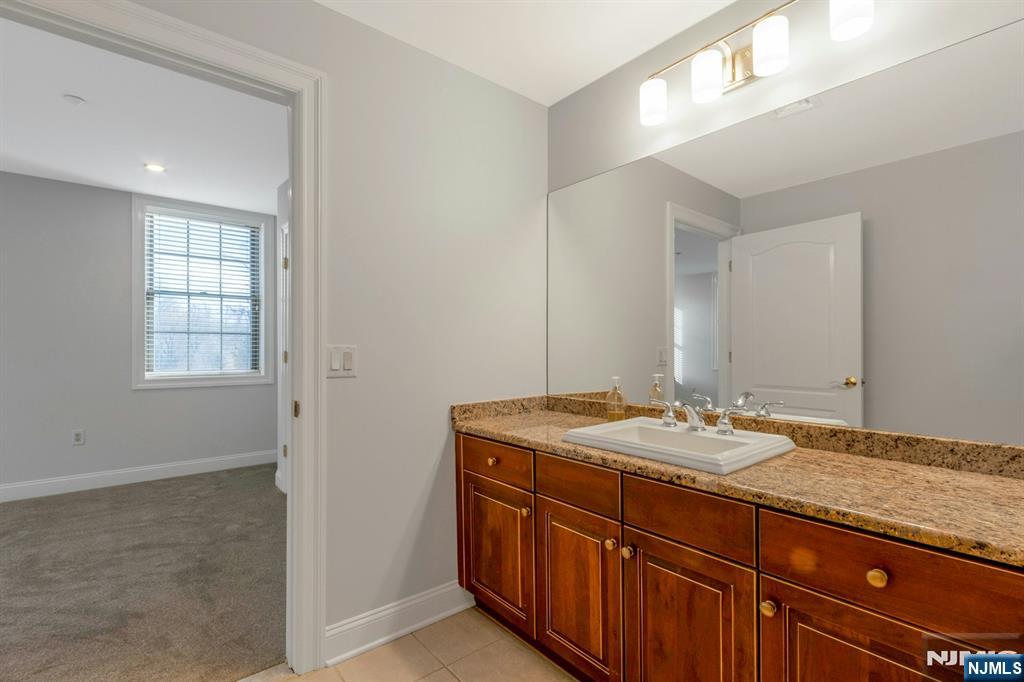 5401 Rio Vista Drive Mahwah, NJ 07430 - Photo 16 of 26 a bathroom with a granite countertop sink and a mirror